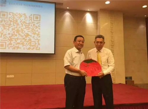 李其教授親手將北京大學標志性的北大西門漆雕工藝禮品贈與躍迪集團董事長呂洪濤